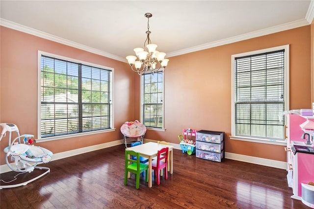 recreation room featuring dark wood-type flooring, a notable chandelier, and ornamental molding