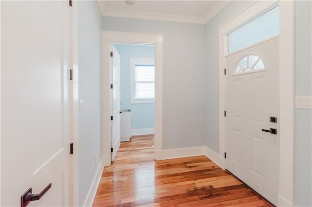 foyer featuring light wood-type flooring and crown molding