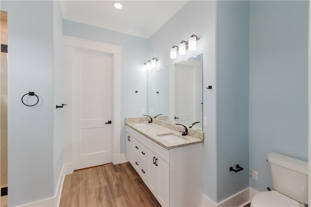 bathroom with wood-type flooring, vanity, and toilet