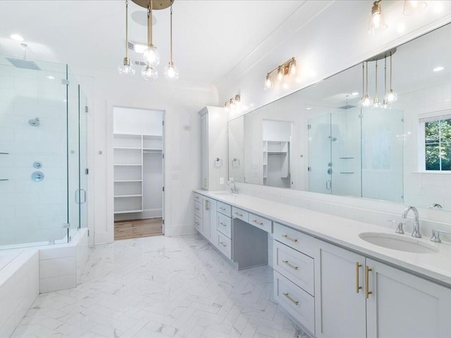 bathroom with a sink, a spacious closet, double vanity, a stall shower, and crown molding