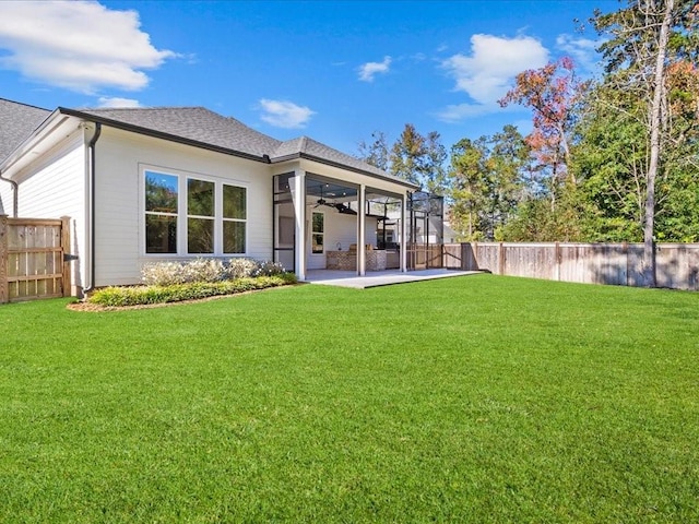 rear view of property featuring a patio area, ceiling fan, a lawn, and a fenced backyard