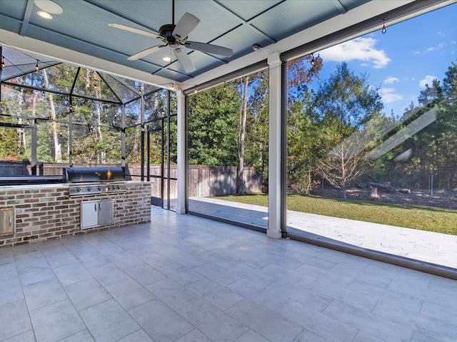 view of patio featuring an outdoor kitchen, fence, ceiling fan, grilling area, and a lanai