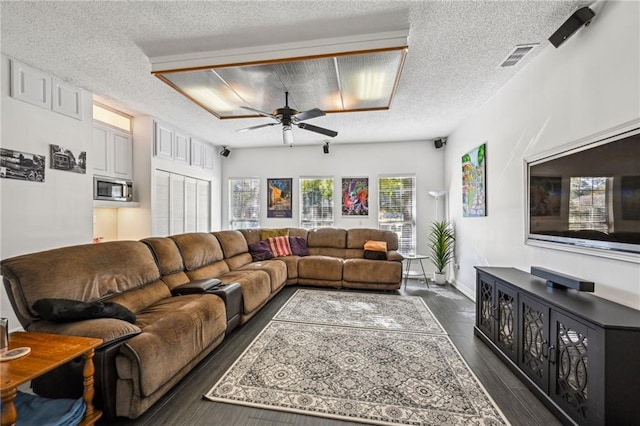 living room featuring a textured ceiling, dark hardwood / wood-style floors, and ceiling fan