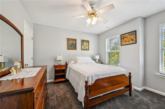 carpeted bedroom featuring ceiling fan and a textured ceiling