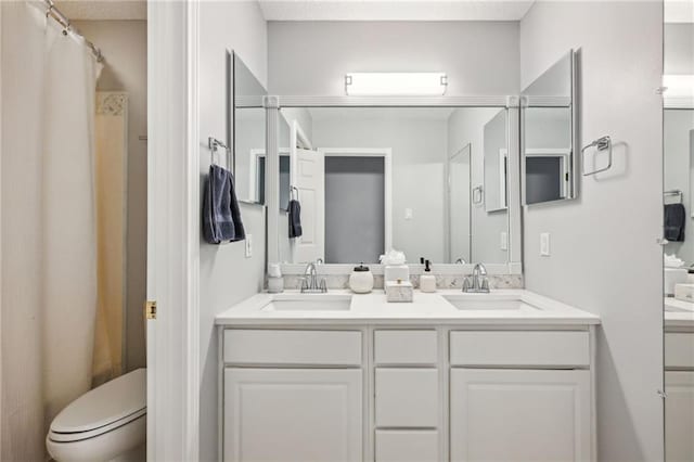 bathroom featuring vanity, curtained shower, and toilet