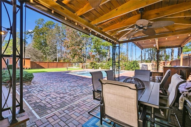 view of patio / terrace featuring a fenced in pool and ceiling fan