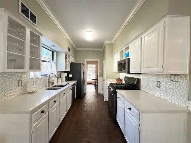 kitchen with white cabinetry, sink, dark hardwood / wood-style floors, crown molding, and appliances with stainless steel finishes