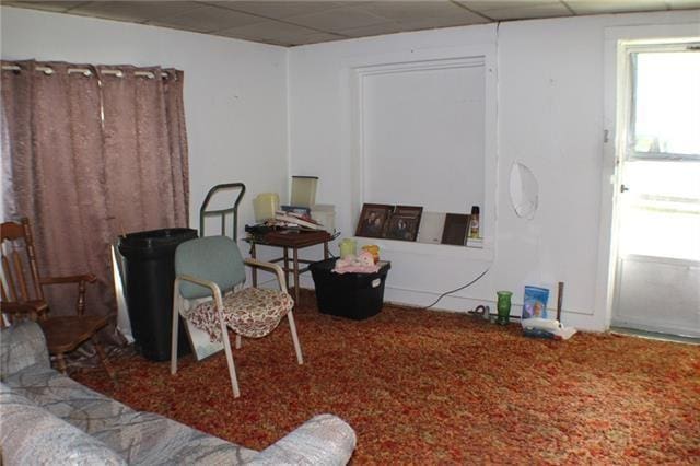 living area with a paneled ceiling