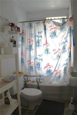 bathroom with toilet and shower / bath combo with shower curtain