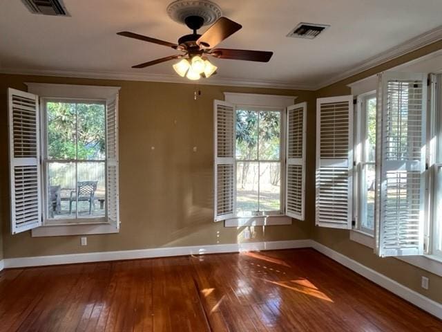 unfurnished room with hardwood / wood-style floors, ceiling fan, and crown molding