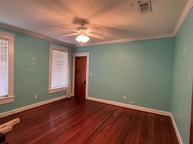 spare room with a healthy amount of sunlight, crown molding, ceiling fan, and dark wood-type flooring