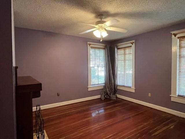 empty room featuring a textured ceiling, dark hardwood / wood-style flooring, and ceiling fan