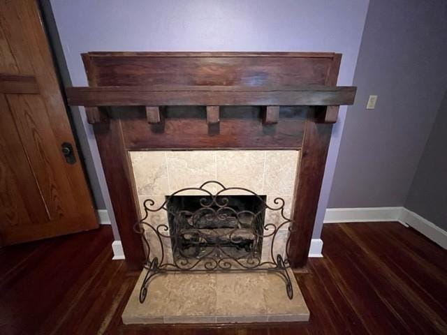 interior details with a tile fireplace and hardwood / wood-style flooring