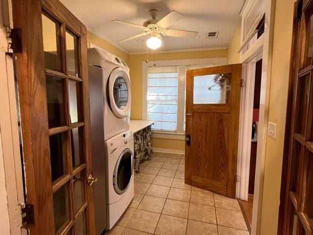 laundry room with ceiling fan, light tile patterned floors, and stacked washer and dryer