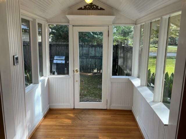 unfurnished sunroom featuring vaulted ceiling