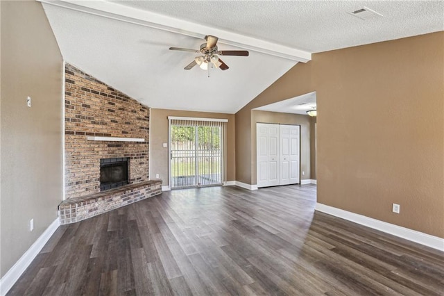 unfurnished living room featuring vaulted ceiling with beams, ceiling fan, a fireplace, a textured ceiling, and dark hardwood / wood-style flooring