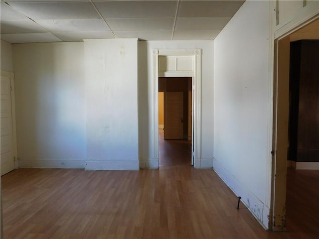 empty room featuring a paneled ceiling and hardwood / wood-style flooring