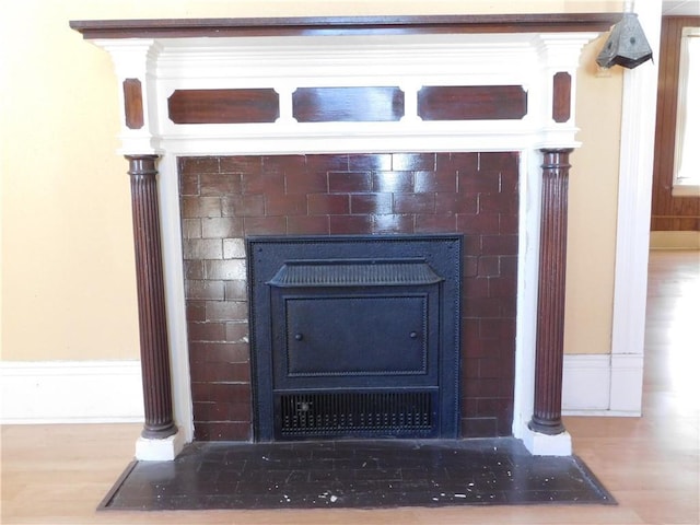 interior details with hardwood / wood-style flooring and a wood stove