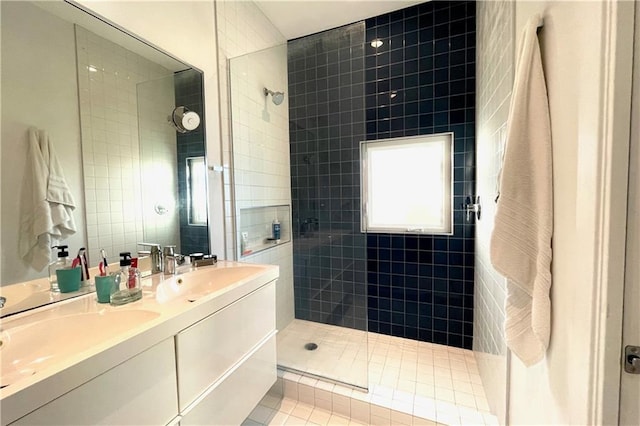 bathroom featuring a tile shower, tile patterned floors, vanity, and tile walls