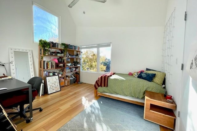 bedroom with hardwood / wood-style floors, vaulted ceiling, and ceiling fan