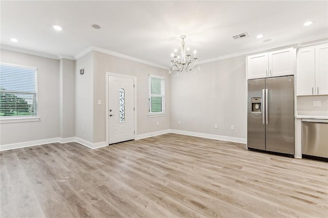 1908-10 St Louis St, New Orleans, LA 70112 - entryway with a chandelier, ornamental molding, plenty of natural light, light wood-style floors, and recessed lighting