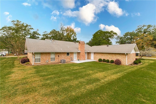 rear view of house featuring a lawn, central AC, and a patio area