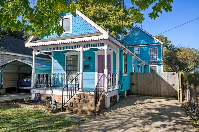419 Romain St, Gretna, LA 70053 - shotgun-style home with a porch and a detached carport