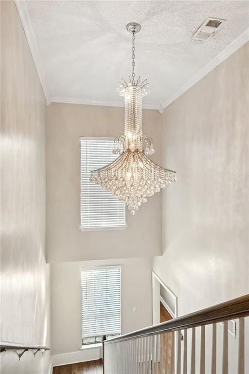 interior space with hardwood / wood-style flooring, a notable chandelier, and crown molding