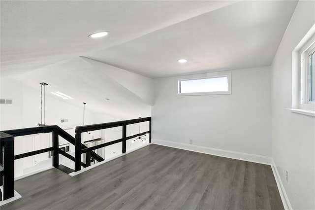 empty room with dark hardwood / wood-style flooring and lofted ceiling