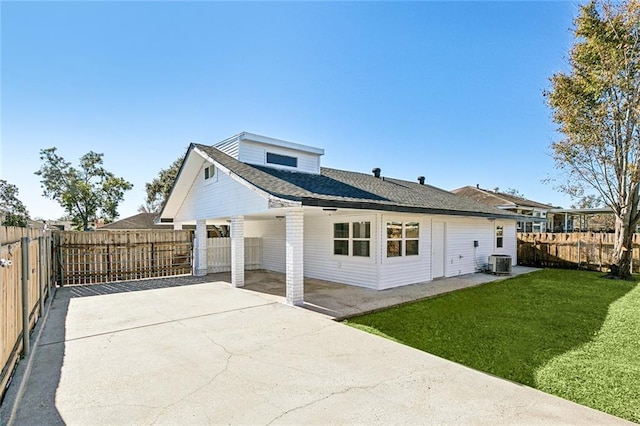 rear view of property with a lawn, central air condition unit, and a patio