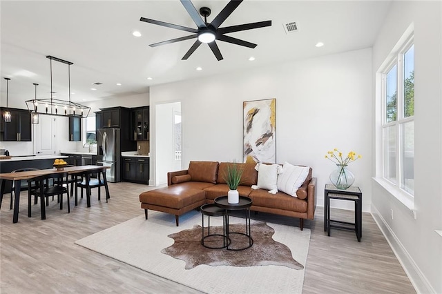 living room with ceiling fan and light hardwood / wood-style flooring