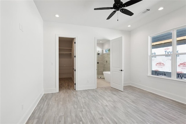 unfurnished bedroom with a walk in closet, ceiling fan, light hardwood / wood-style flooring, connected bathroom, and a closet