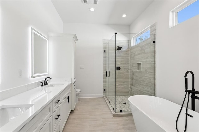 full bathroom featuring separate shower and tub, vanity, and toilet