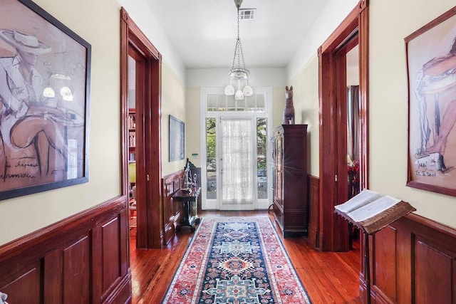 entryway featuring dark wood-type flooring and a notable chandelier