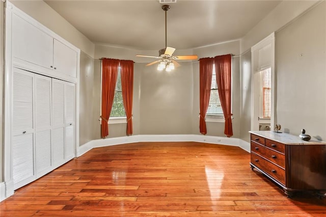 dining room featuring light wood-style flooring, baseboards, and a ceiling fan