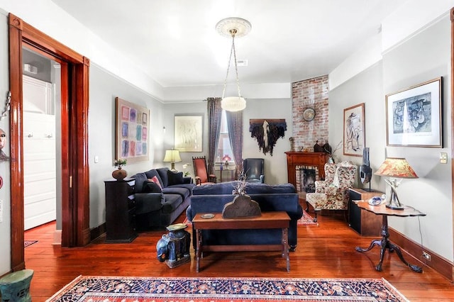 living room featuring hardwood / wood-style floors and a brick fireplace