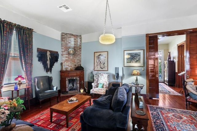 living room featuring a fireplace, dark hardwood / wood-style floors, and a wealth of natural light