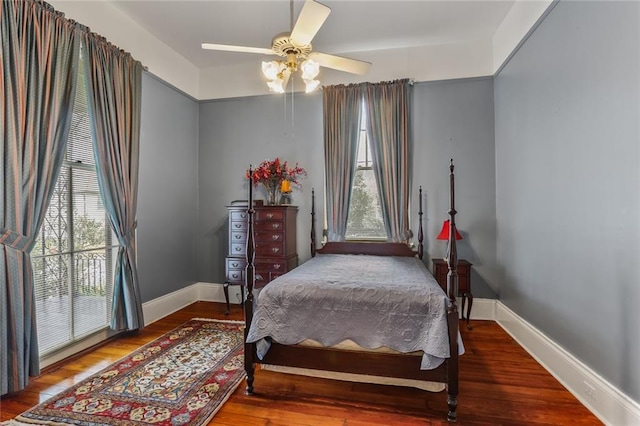 bedroom with wood finished floors, a ceiling fan, and baseboards