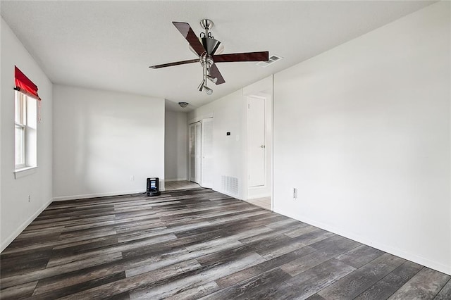 empty room with ceiling fan and dark wood-type flooring