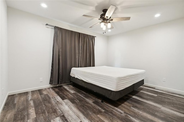 bedroom with dark hardwood / wood-style flooring and ceiling fan