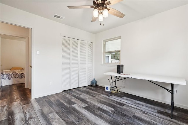 home office with dark hardwood / wood-style floors and ceiling fan