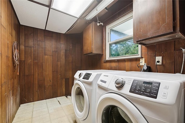 laundry area with wood walls, cabinets, and independent washer and dryer