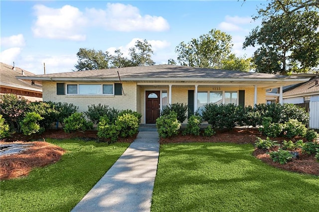 ranch-style home featuring a porch and a front yard