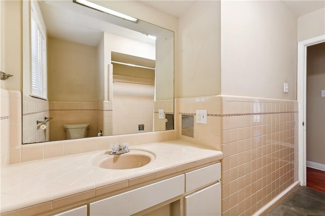 bathroom with vanity, tile walls, and toilet