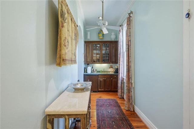 hall featuring light hardwood / wood-style floors, ornamental molding, and sink