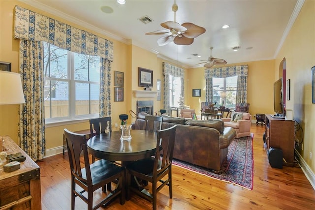 dining space with ceiling fan, light hardwood / wood-style floors, and crown molding