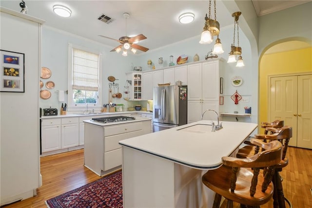 kitchen with a center island, sink, white cabinetry, light hardwood / wood-style floors, and stainless steel fridge with ice dispenser