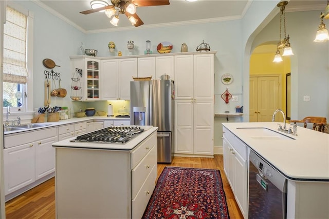 kitchen featuring decorative light fixtures, a center island, sink, and stainless steel appliances