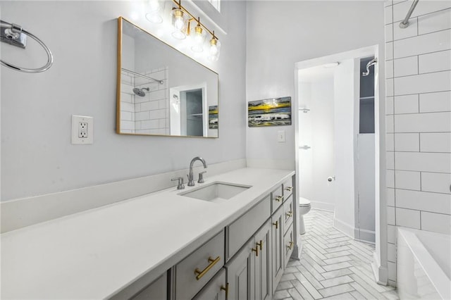 full bathroom featuring vanity, tiled shower / bath, and toilet