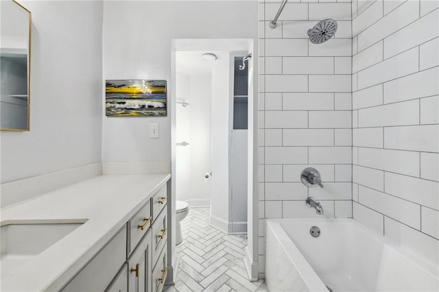 full bathroom with tiled shower / bath, vanity, and toilet